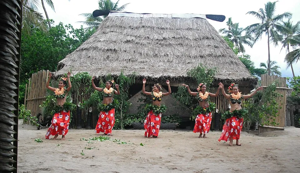 Dancers in front of a thatched bure in Fiji
