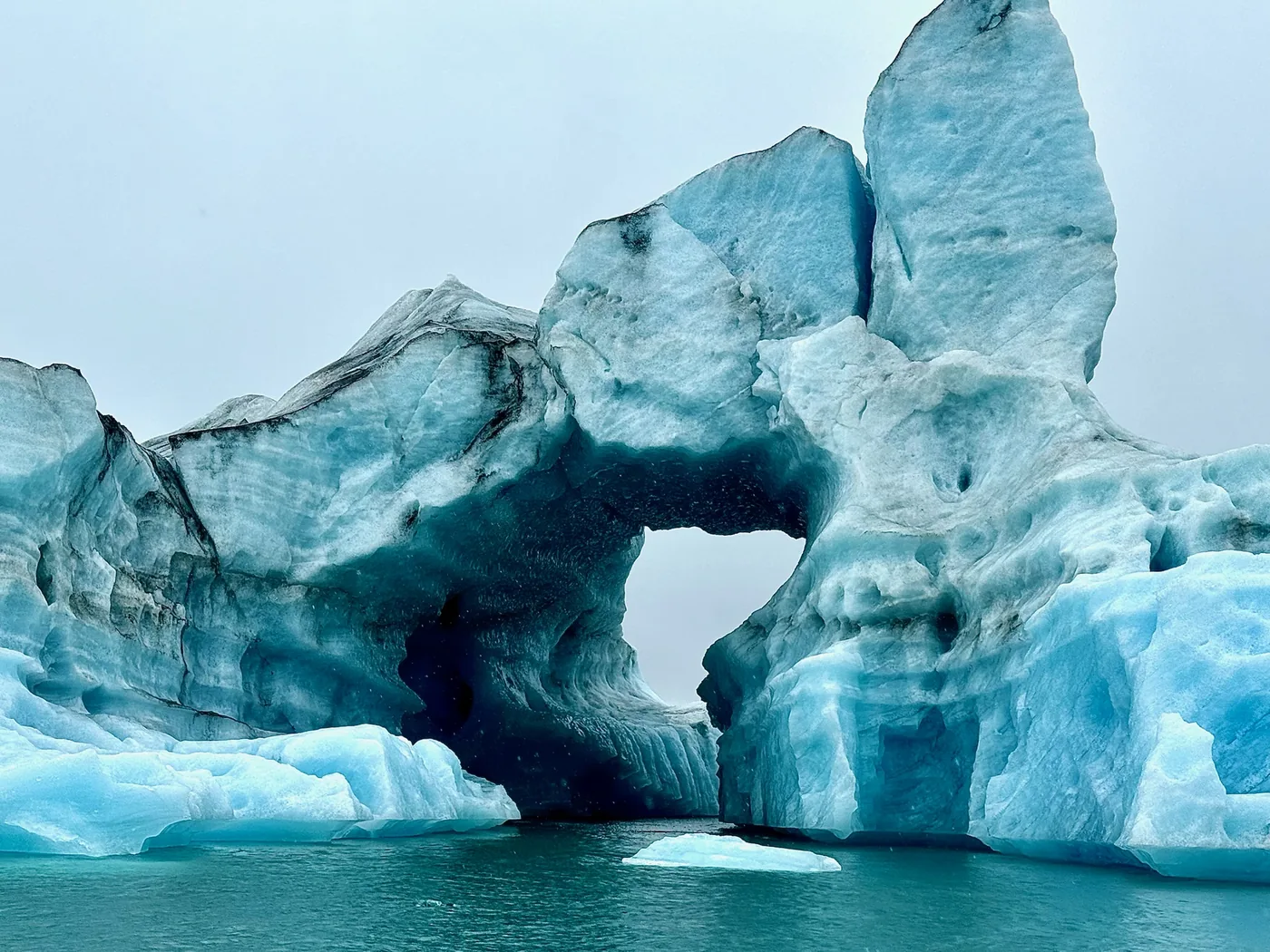 A blue iceberg arch on the glacier lagoon